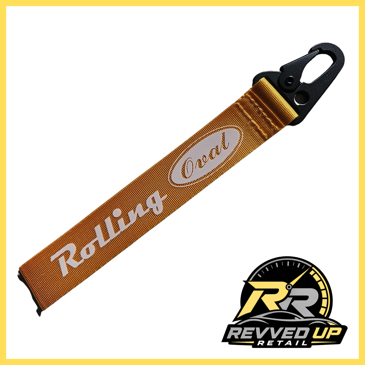 A Rolling Oval brand wristlet strap in yellow with white printed logos and a black metal carabiner clip, shown on a white background with a Revved Up Retail watermark.