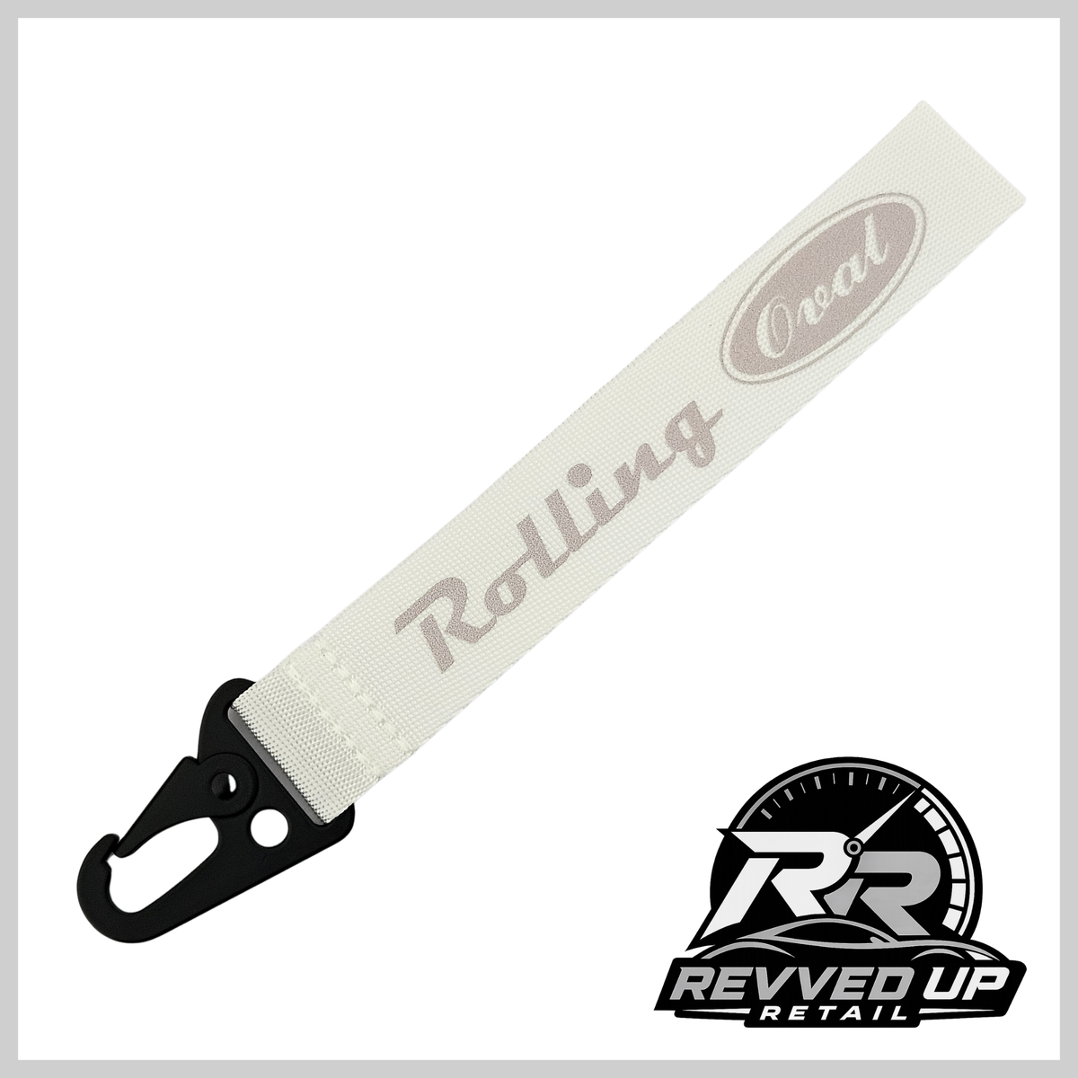 A Rolling Oval brand wristlet strap in white with grey printed logos and a black metal carabiner clip, shown on a white background with a Revved Up Retail watermark.