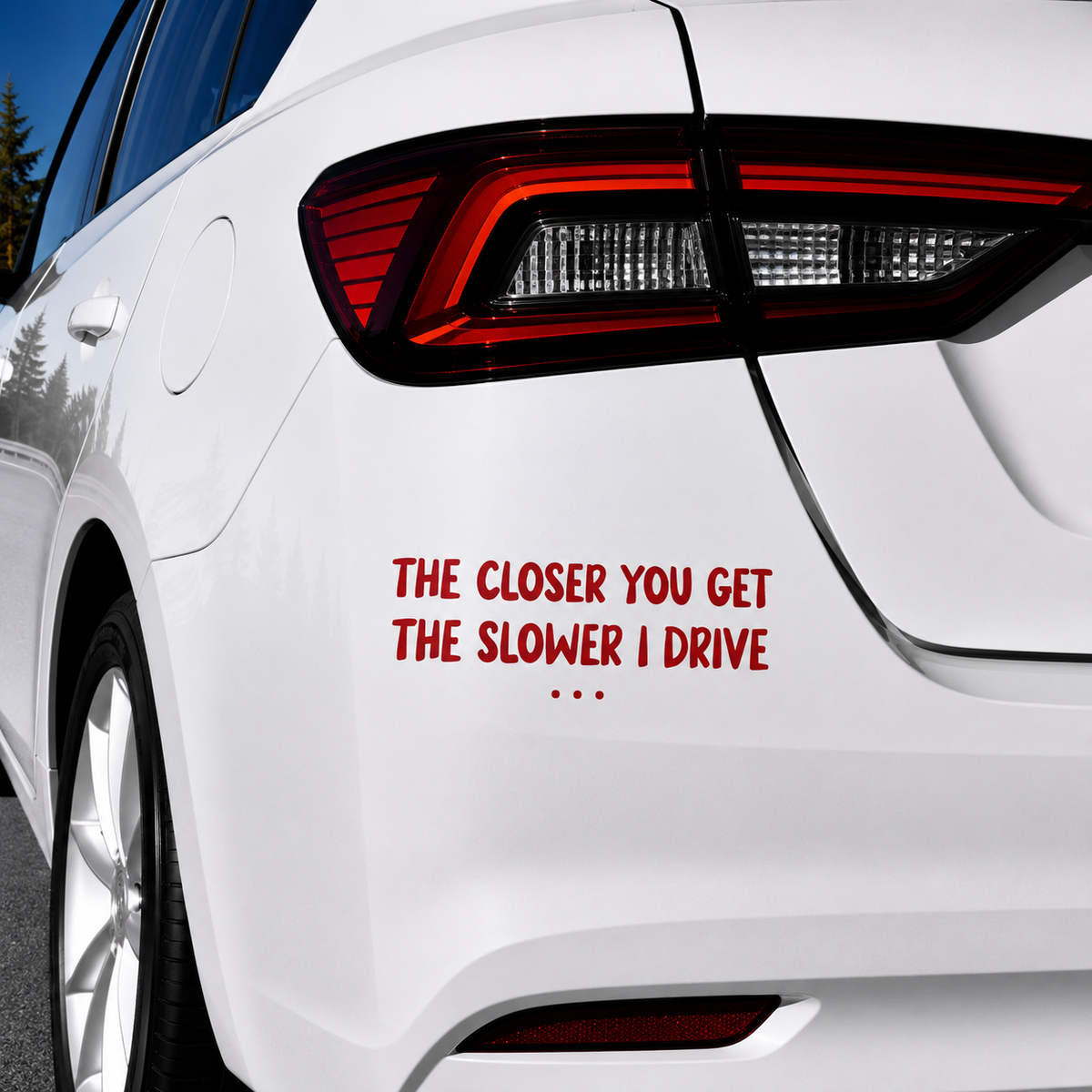 A red vinyl decal with the humorous text 'THE CLOSER YOU GET THE SLOWER I DRIVE .