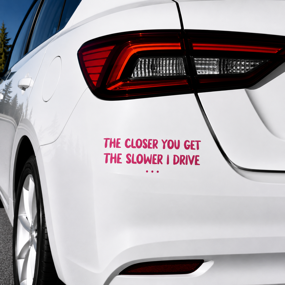 A red vinyl decal with the humorous text 'THE CLOSER YOU GET THE SLOWER I DRIVE .