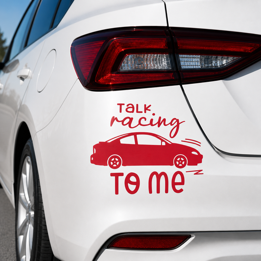 A red vinyl car decal applied to the rear quarter panel of a white car. The decal features the text 'TALK racing TO ME' in red script and block lettering, along with a red side-profile illustration of a sports car.
