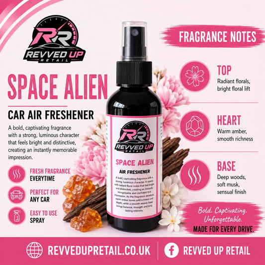 Revved Up Retail Space Alien Car Air Freshener bottle in the center, surrounded by pink floral graphics, cinnamon sticks, amber crystals, and fragrance notes text on a pink and white background.