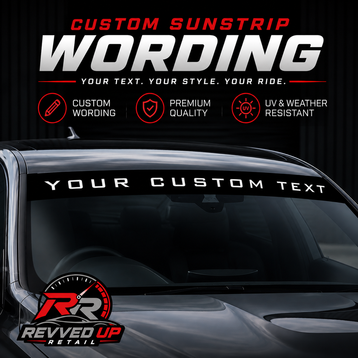 A custom sunstrip decal banner displayed on the windshield of a dark car, featuring customizable white text on a black background with promotional text and the Revved Up Retail logo.