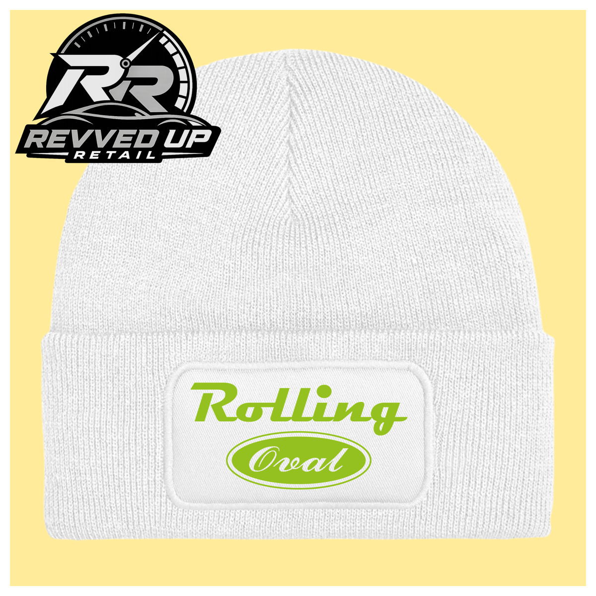 A white ribbed knit beanie with a cuffed brim, featuring a white rectangular patch on the front with the words 'Rolling Oval' in green. The beanie is shown against a pale yellow background with a Revved Up Retail logo in the top-left corner.