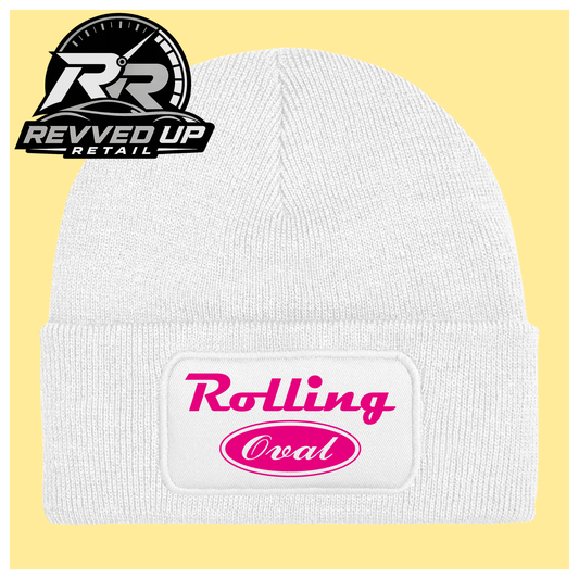A white ribbed knit beanie with a folded cuff featuring a white patch that reads 'Rolling Oval' in pink. The beanie is shown on a pale yellow background with a Revved Up Retail logo in the top-left corner.