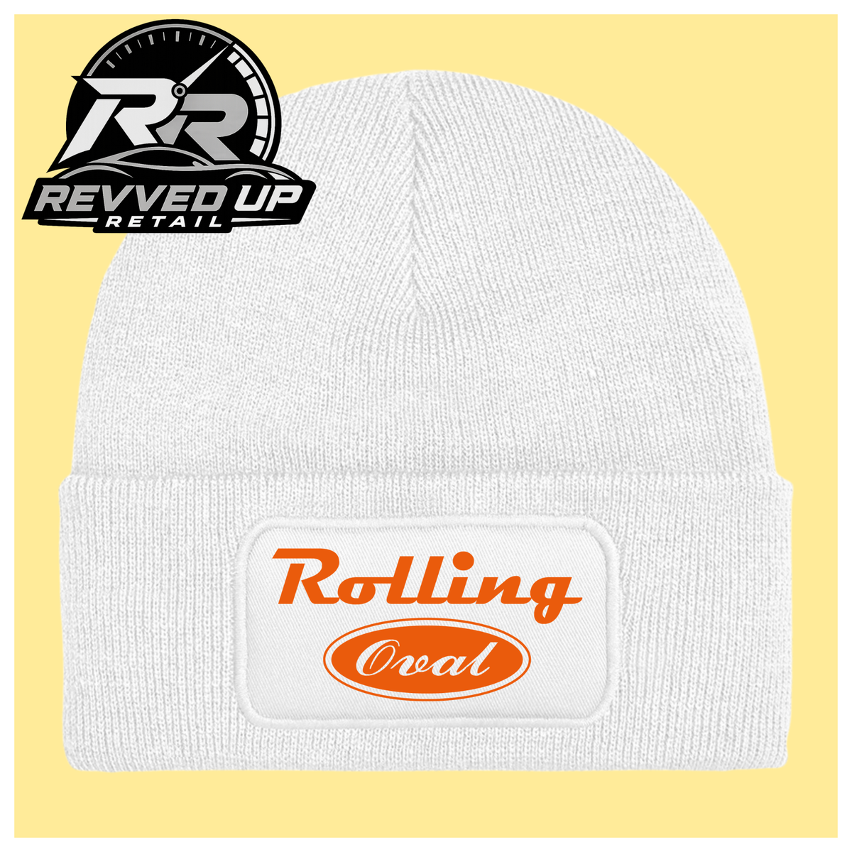 A white ribbed knit beanie with a folded cuff featuring a white patch that reads 'Rolling Oval' in orange. The beanie is centered on a pale yellow background, with a Revved Up Retail logo in the top-left corner.