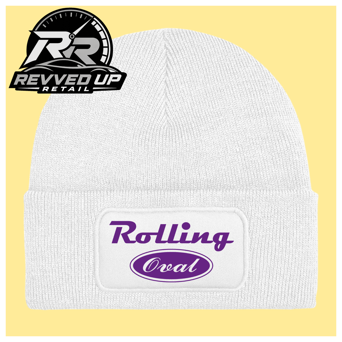A white ribbed knit beanie with a folded cuff featuring a white patch that reads 'Rolling Oval' in purple. The beanie is centered on a pale yellow background, with a Revved Up Retail logo overlay in the top-left corner.