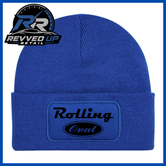 A royal blue ribbed knit beanie with a folded cuff featuring an oval patch that reads 'Rolling Oval' in black. A Revved Up Retail logo is displayed in the top-left corner.