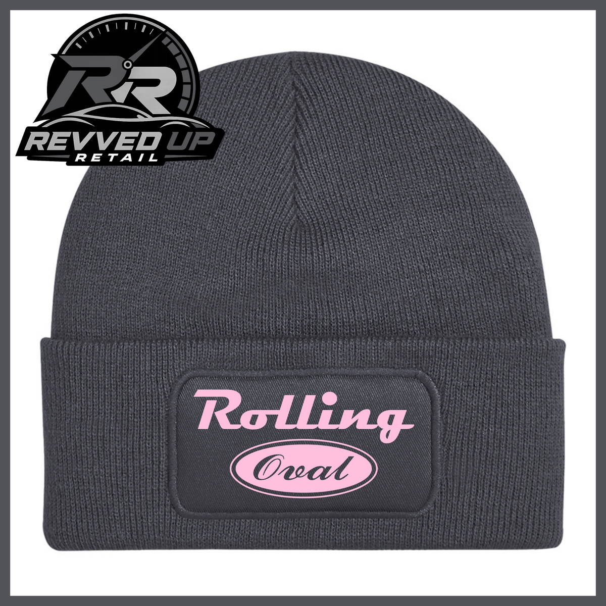 A dark grey ribbed knit beanie with a folded cuff featuring a black patch that reads 'Rolling Oval' in pale pink. A Revved Up Retail logo is visible in the top-left corner.