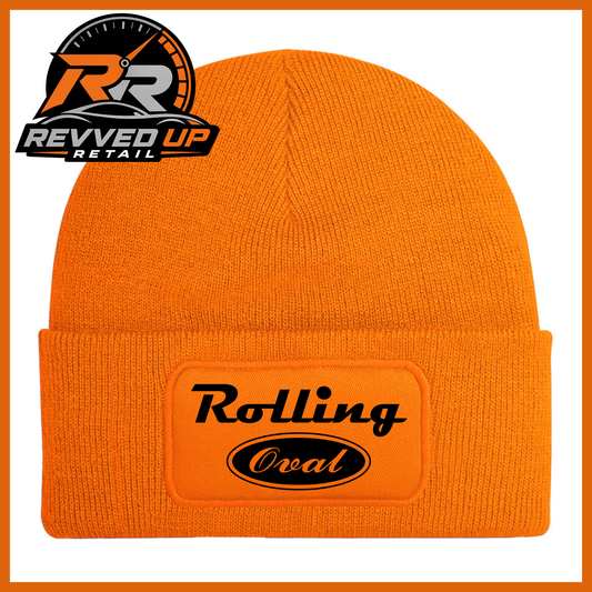 An orange ribbed knit beanie hat with a cuffed brim, featuring a rectangular patch on the front that reads 'Rolling Oval' in black. A Revved Up Retail logo is visible in the top-left corner.