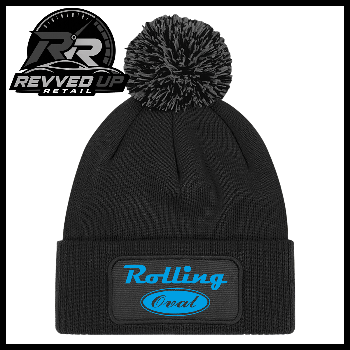 A black ribbed knit pom-pom beanie with a folded cuff featuring an oval black patch with blue text reading 'Rolling Oval'. A Revved Up Retail logo is visible in the top-left corner.