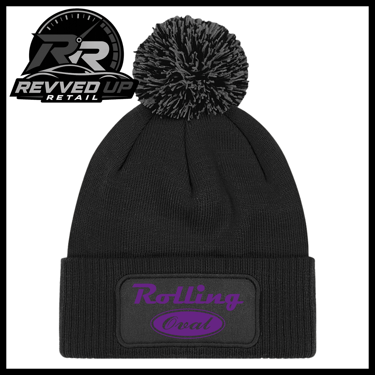 A black ribbed knit pom-pom beanie with a folded cuff featuring an oval black patch with purple text reading 'Rolling Oval'. A Revved Up Retail logo is visible in the top-left corner.