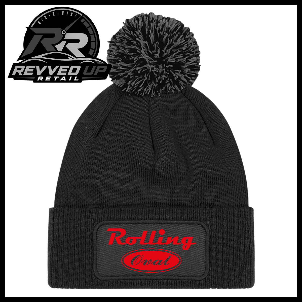 A black ribbed knit pom-pom beanie with a folded cuff featuring an oval black patch with red text reading 'Rolling Oval'. A Revved Up Retail logo is visible in the top-left corner.