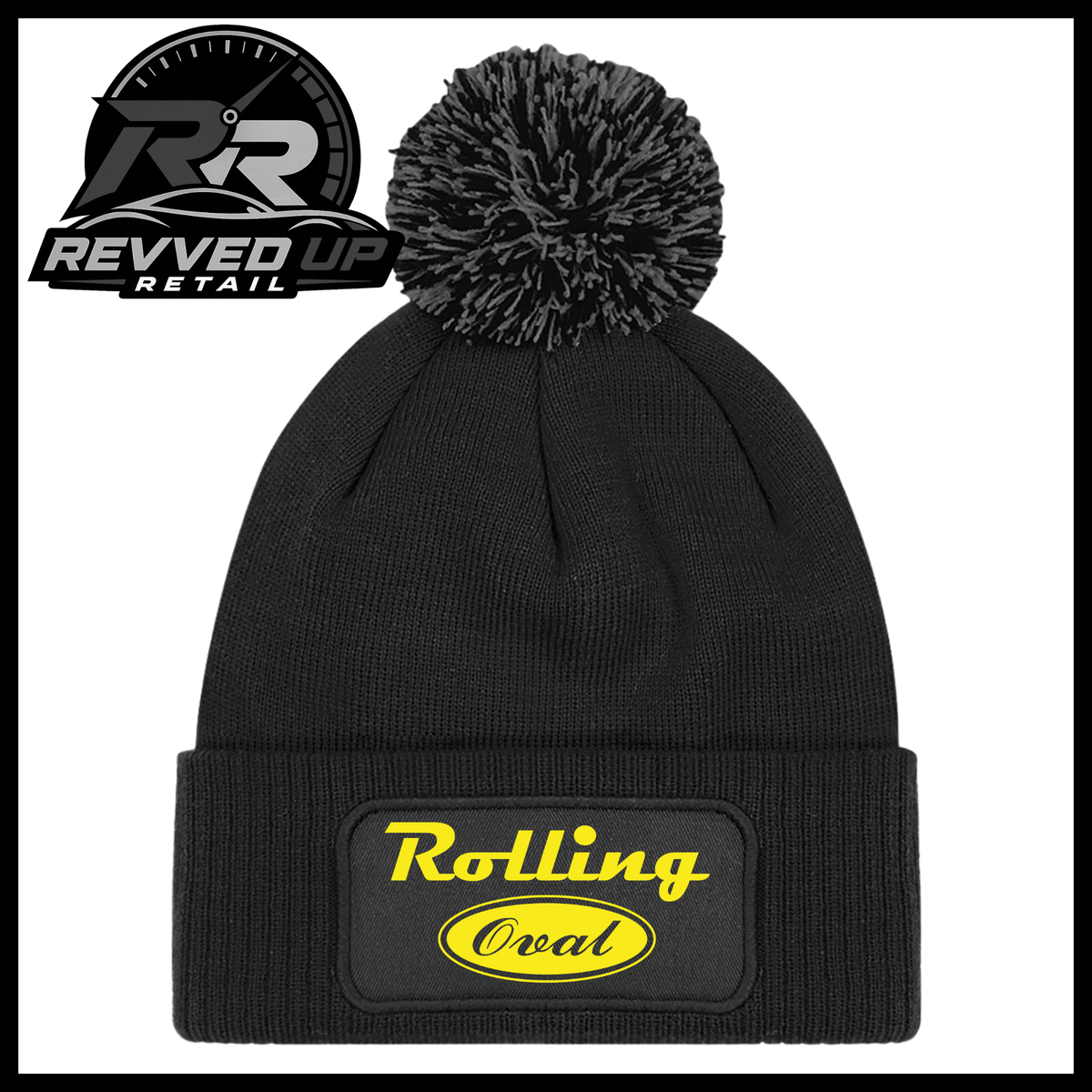 A black ribbed knit pom-pom beanie with a folded cuff featuring an oval black patch with yellow text reading 'Rolling Oval'. A Revved Up Retail logo is visible in the top-left corner.