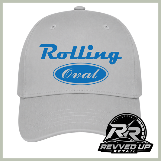 A light gray baseball cap with blue text reading 'Rolling Oval' on the front, plus a Revved Up Retail logo badge in the lower right corner.