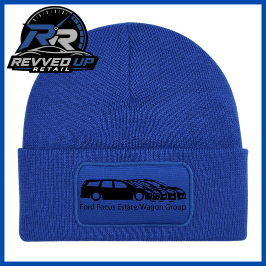 A royal blue knit beanie with a folded cuff featuring a rectangular patch that reads 'Ford Focus Estate/Wagon Group' with a black car graphic. The Revved Up Retail logo is displayed in the top-left corner.