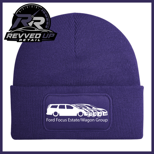 A purple knit beanie with a folded cuff featuring a rectangular patch that reads 'Ford Focus Estate/Wagon Group' with a white car graphic. The Revved Up Retail logo is displayed in the top-left corner.
