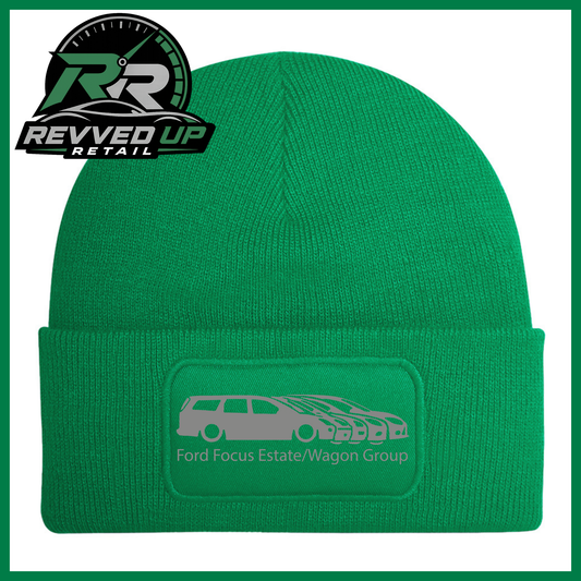 A green knit beanie with a folded cuff featuring a rectangular patch that reads 'Ford Focus Estate/Wagon Group' with a grey car graphic. The Revved Up Retail logo is displayed in the top-left corner.