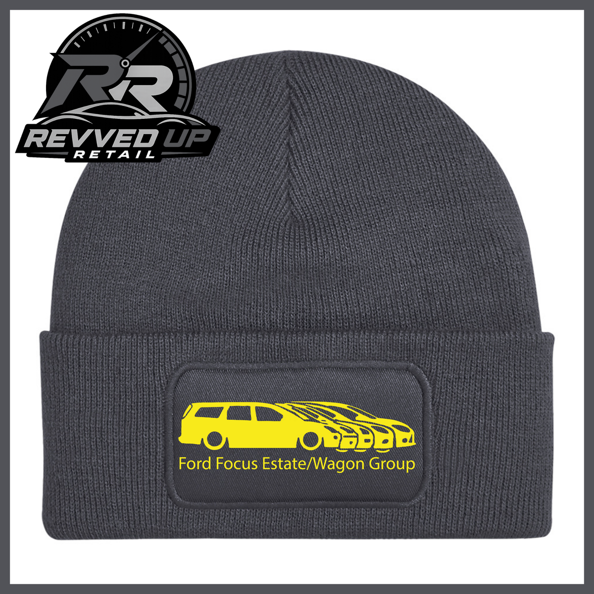 A grey ribbed knit beanie with a folded cuff, featuring a black rectangular patch with a yellow car graphic and the text 'Ford Focus Estate/Wagon Group.' A Revved Up Retail logo appears in the top-left corner.