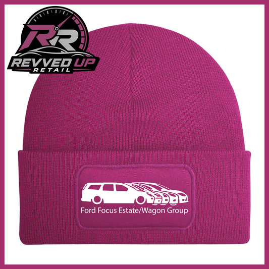 A fuchsia knit beanie with a folded cuff featuring a rectangular patch that reads 'Ford Focus Estate/Wagon Group' with a white car graphic. The Revved Up Retail logo is displayed in the top-left corner.
