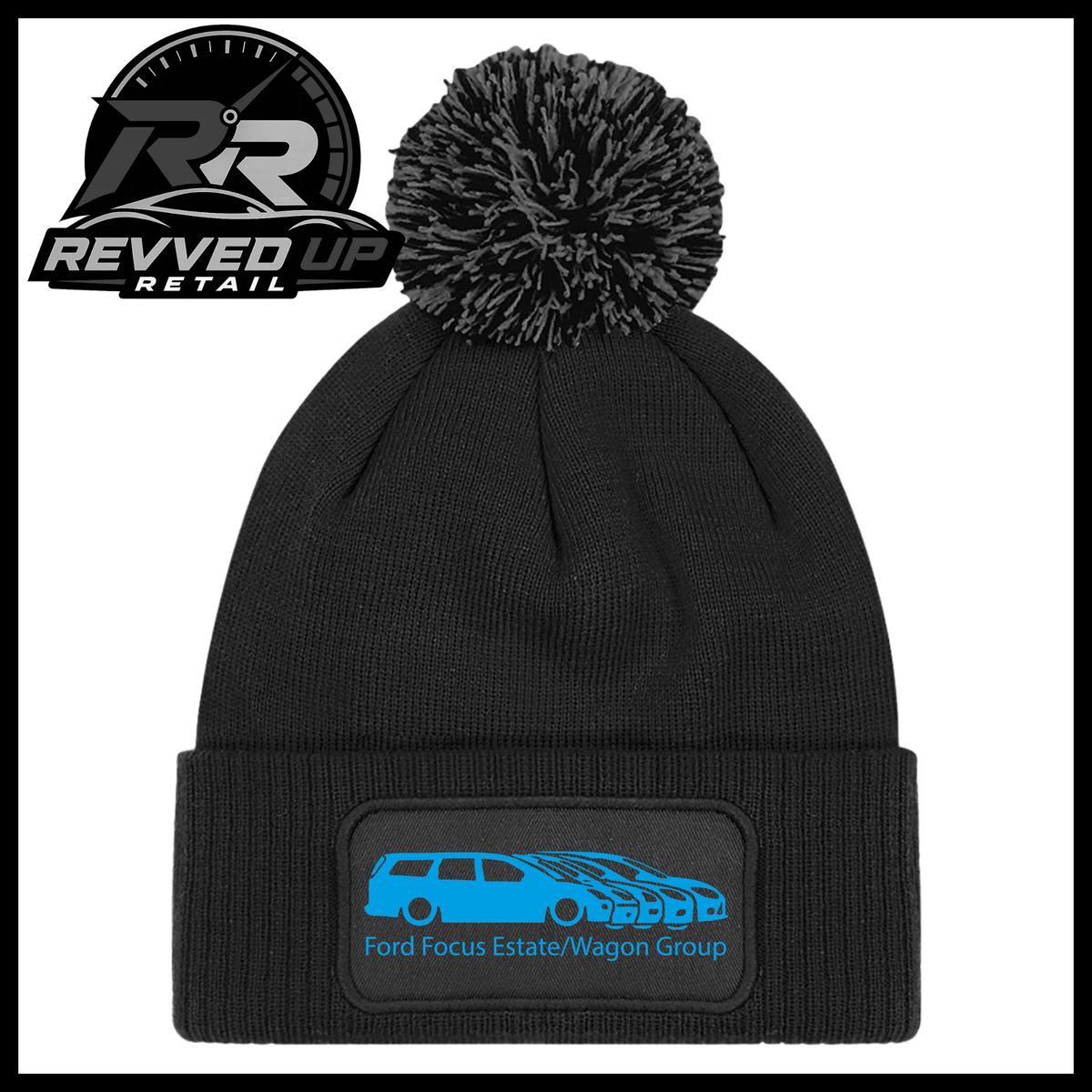 A black knit pom-pom beanie with a folded cuff featuring a black patch with a light blue car graphic and the text 'Ford Focus Estate/Wagon Group'. A Revved Up Retail logo is visible in the top-left corner.