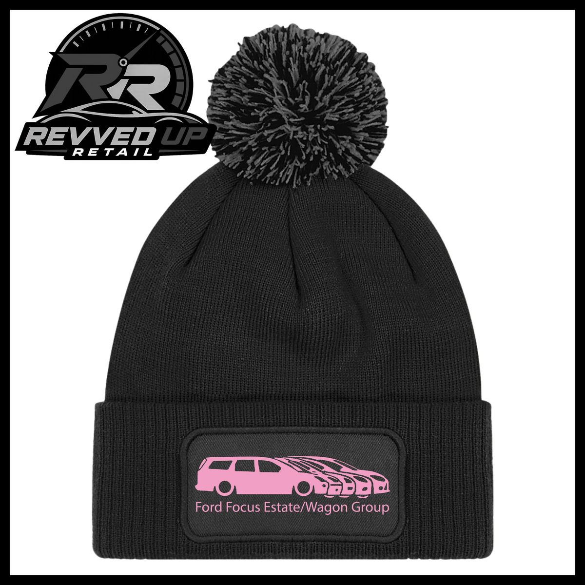 A black knit pom-pom beanie with a folded cuff featuring a black patch with a pale pink car graphic and the text 'Ford Focus Estate/Wagon Group'. A Revved Up Retail logo is visible in the top-left corner.