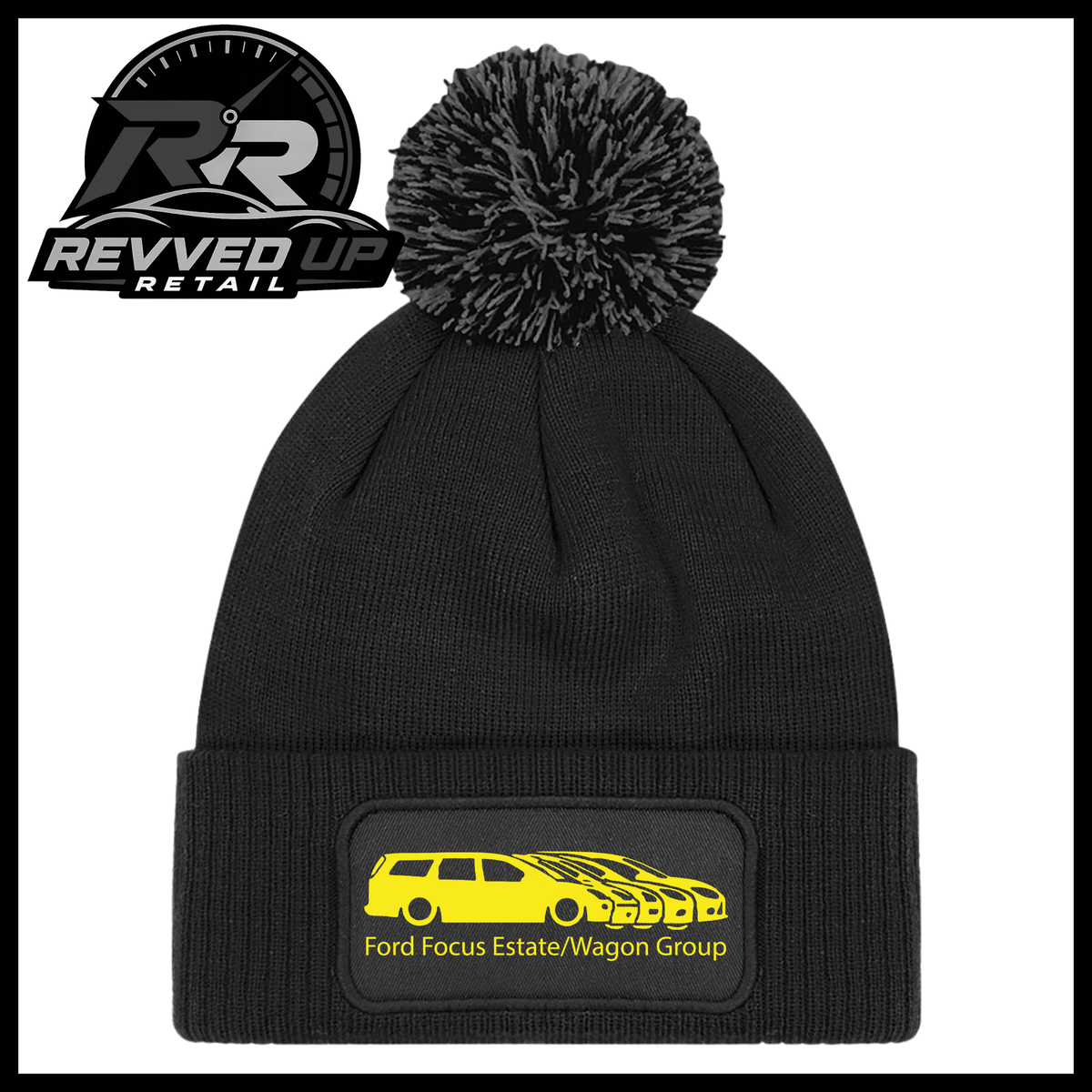 A black knit pom-pom beanie with a folded cuff featuring a black patch with a yellow car graphic and the text 'Ford Focus Estate/Wagon Group'. A Revved Up Retail logo is visible in the top-left corner.