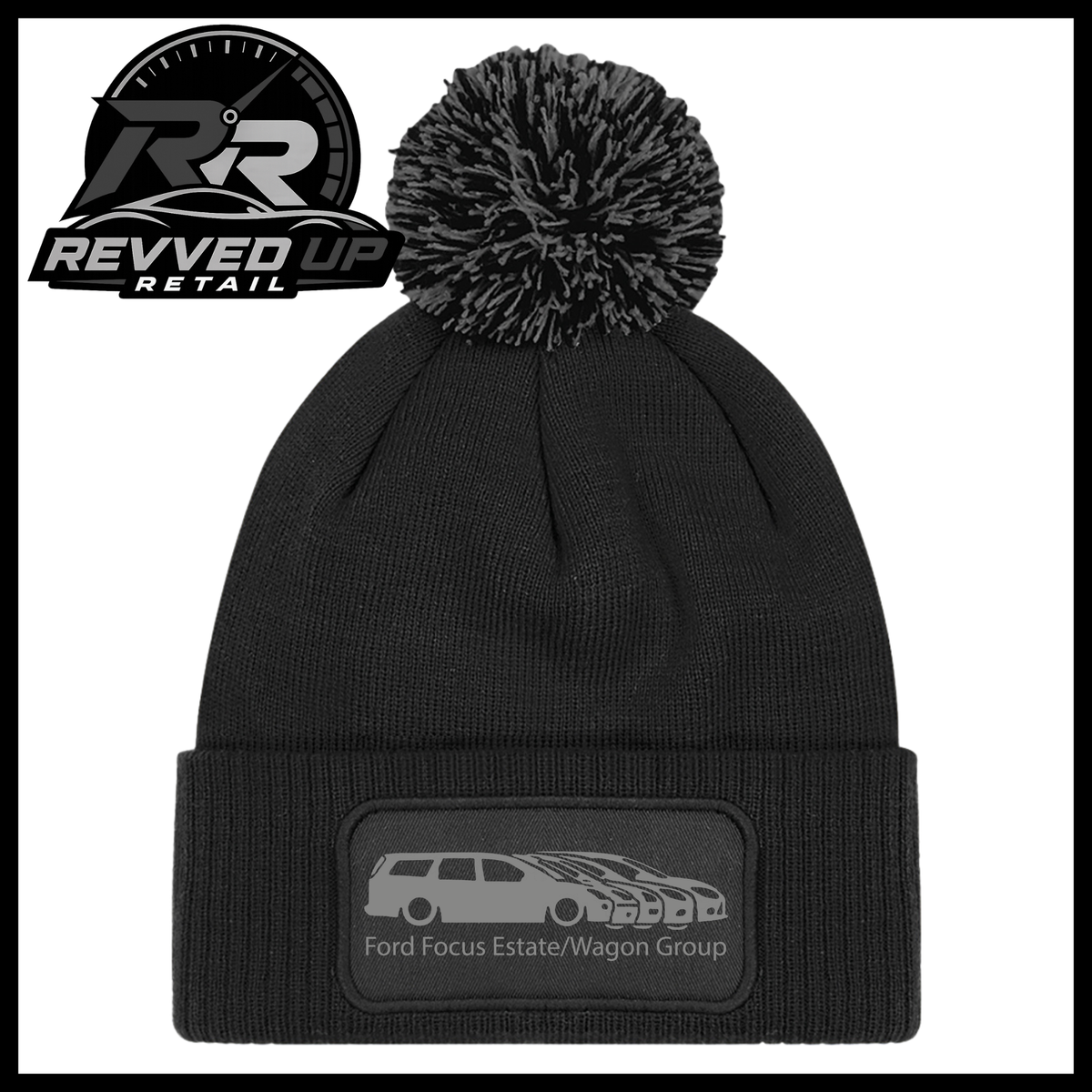 A black knit pom-pom beanie with a folded cuff featuring a black patch with a grey car graphic and the text 'Ford Focus Estate/Wagon Group'. A Revved Up Retail logo is visible in the top-left corner.