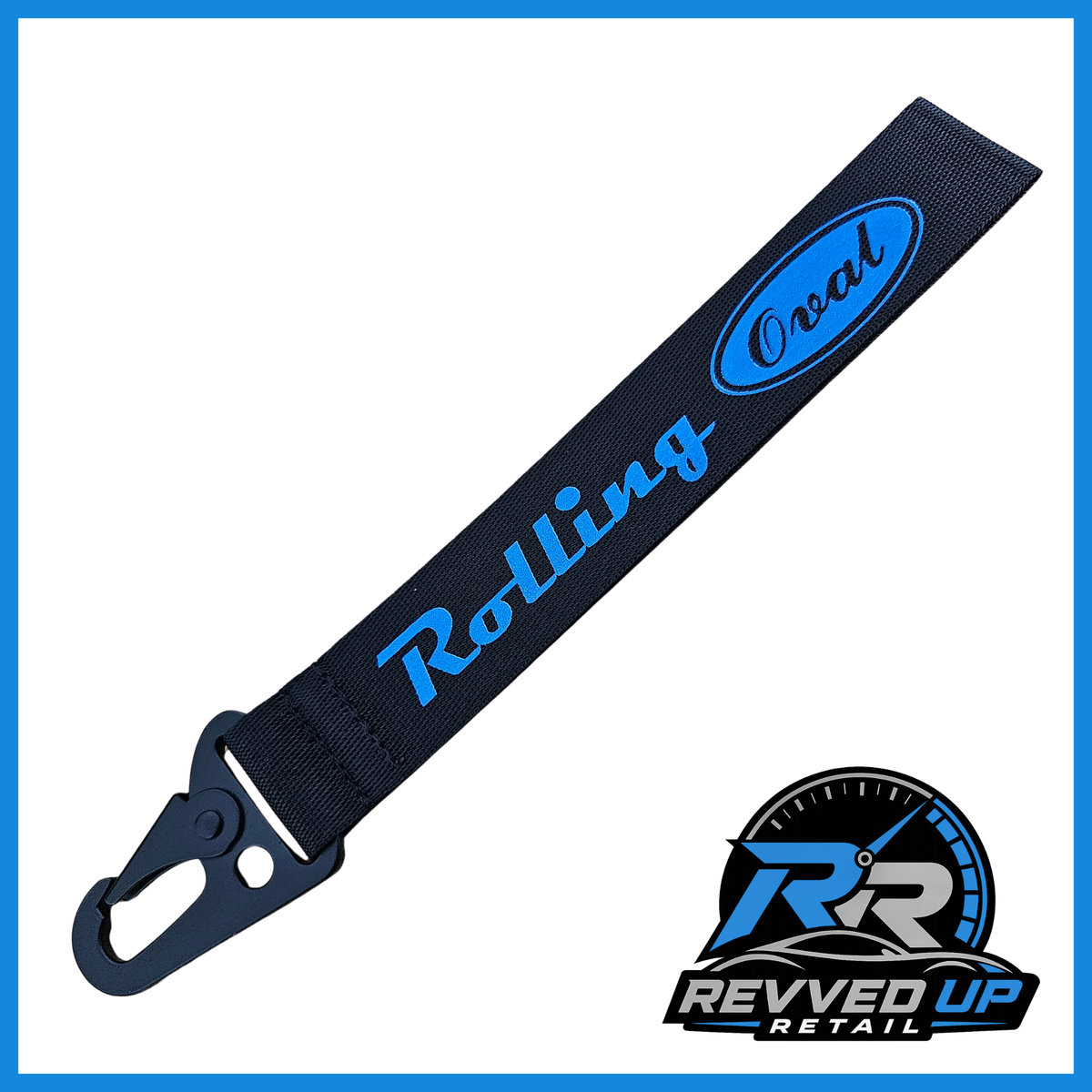 A Rolling Oval brand wristlet strap in black with dark blue printed logos and a black metal carabiner clip, shown on a white background with a Revved Up Retail watermark.