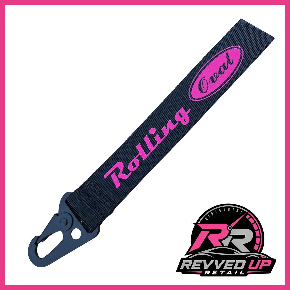 A Rolling Oval brand wristlet strap in black with hot pink printed logos and a black metal carabiner clip, shown on a white background with a Revved Up Retail watermark.