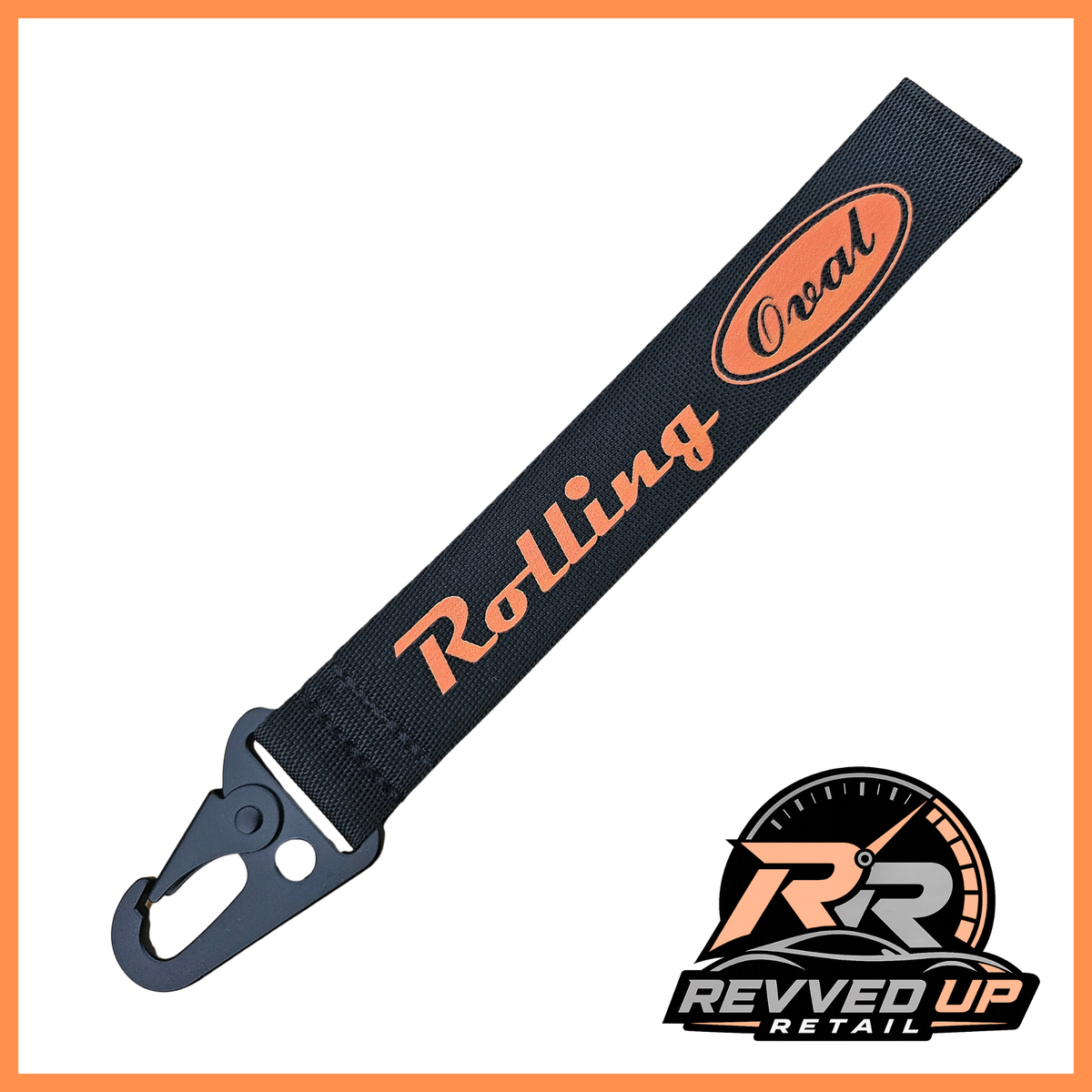 A Rolling Oval brand wristlet strap in black with orange printed logos and a black metal carabiner clip, shown on a white background with a Revved Up Retail watermark.