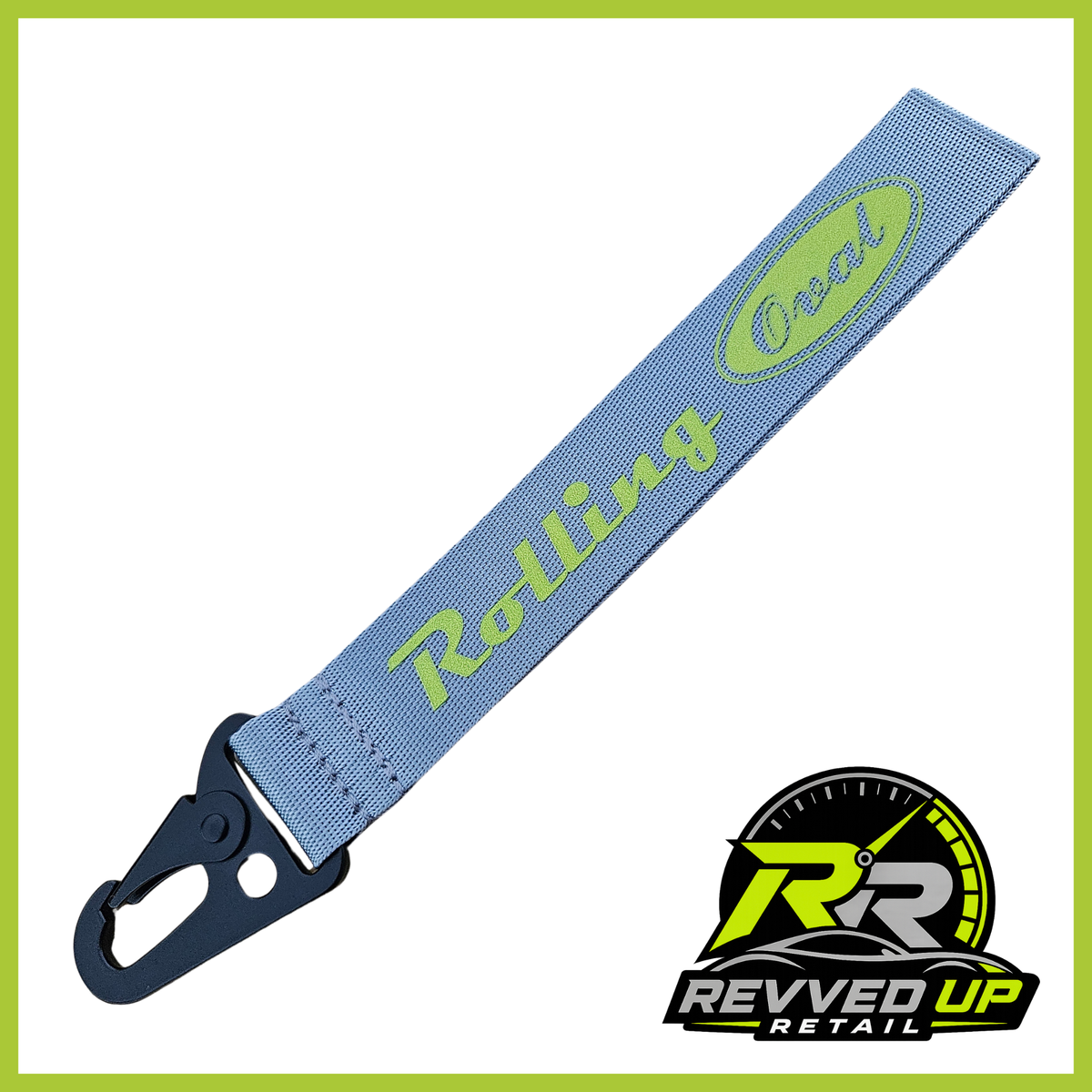 A Rolling Oval brand wristlet strap in grey with green printed logos and a black metal carabiner clip, shown on a white background with a Revved Up Retail watermark.