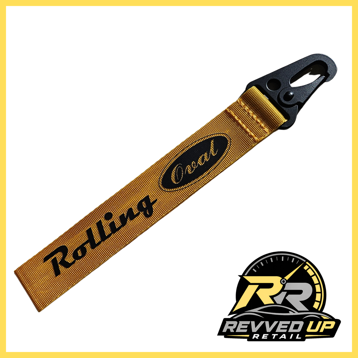 A Rolling Oval brand wristlet strap in yellow with black printed logos and a black metal carabiner clip, shown on a white background with a Revved Up Retail watermark.