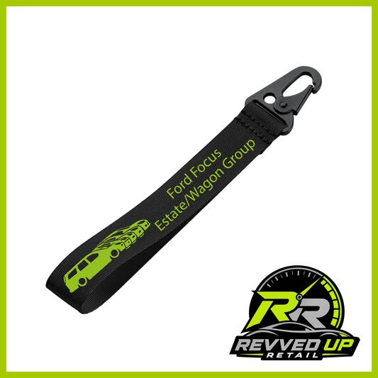 A Ford Focus Estate/Wagon Group brand wristlet strap in black with green printed logos and a black metal carabiner clip, shown on a white background with a Revved Up Retail watermark.